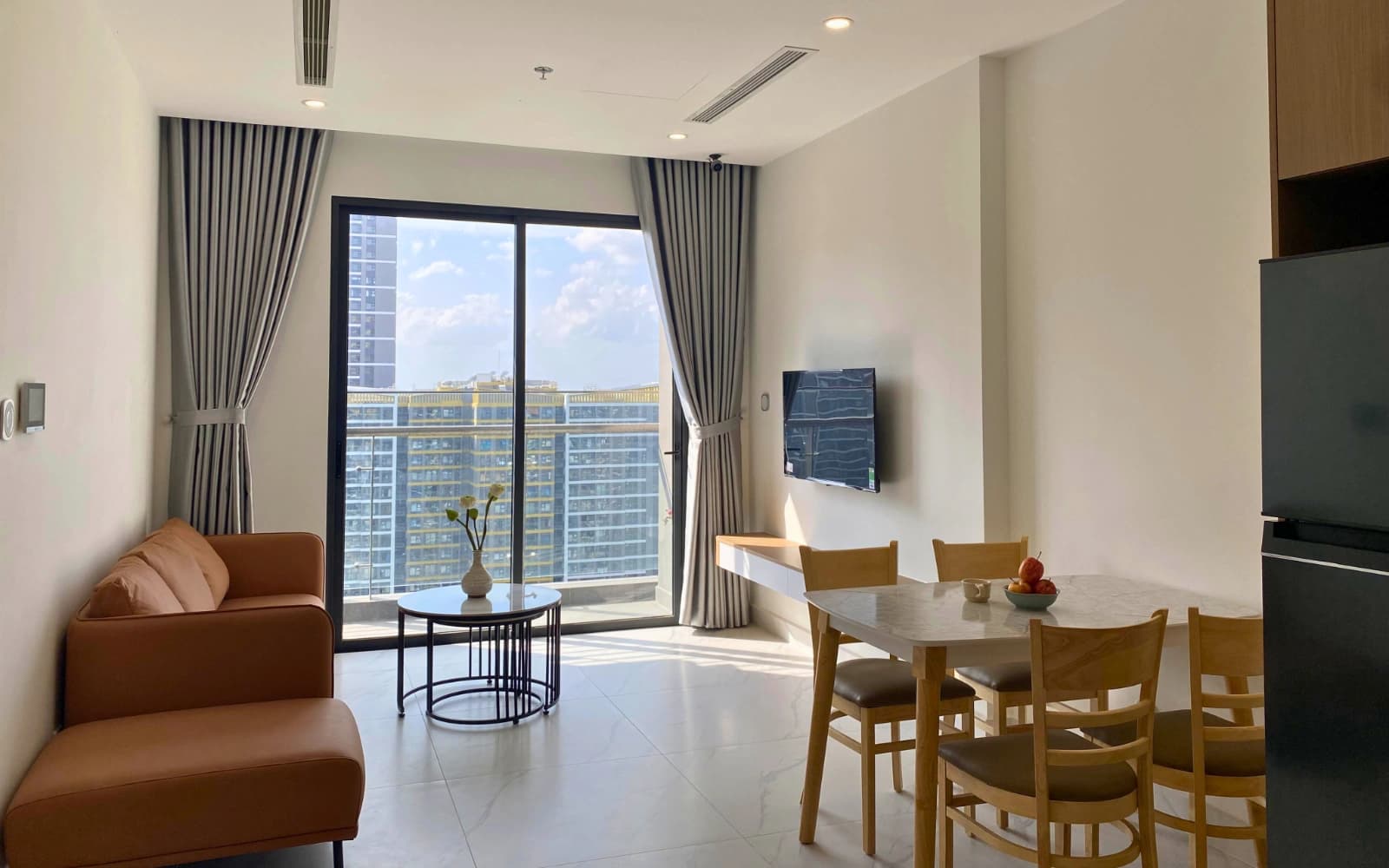 Phòng ngủ căn hộ Vinhomes Quận 9 với tủ áo trắng kịch trần và góc học tập gọn gàng